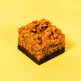 Caramel Cornflake Brownie with fudgy chocolate base and crispy caramel cornflake topping by Crumbs & Doilies on yellow background